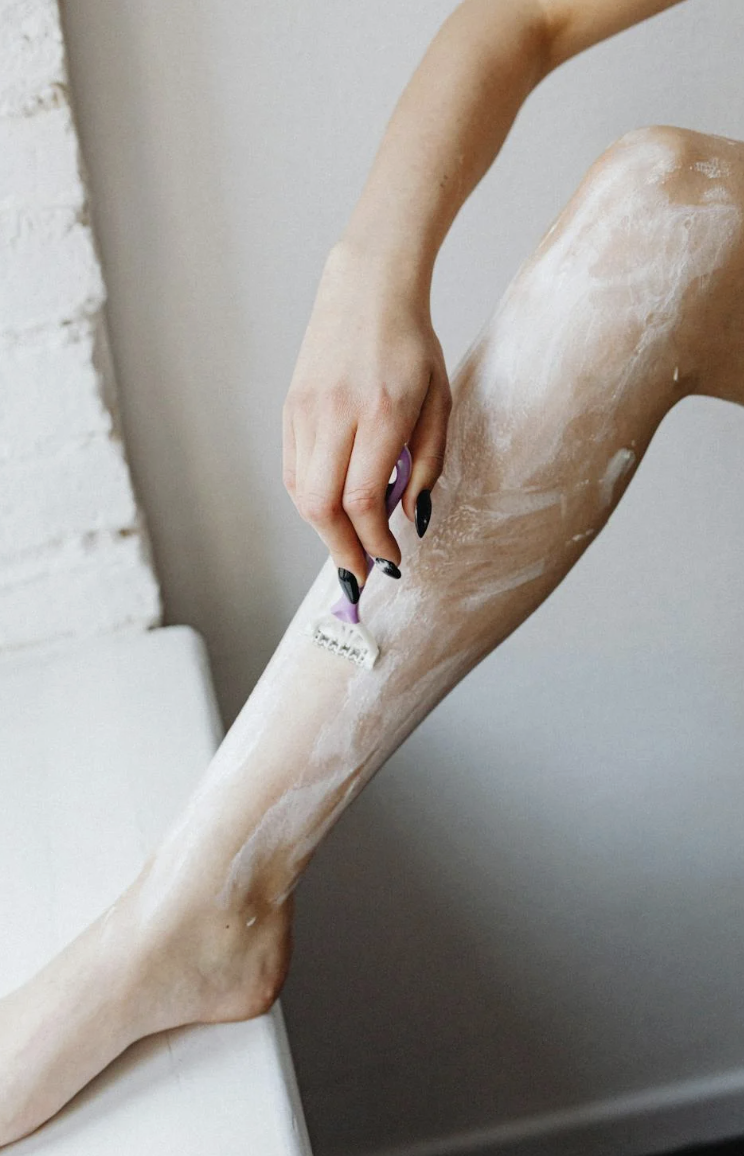 women's shaving essentials razor and cream on bathroom counter