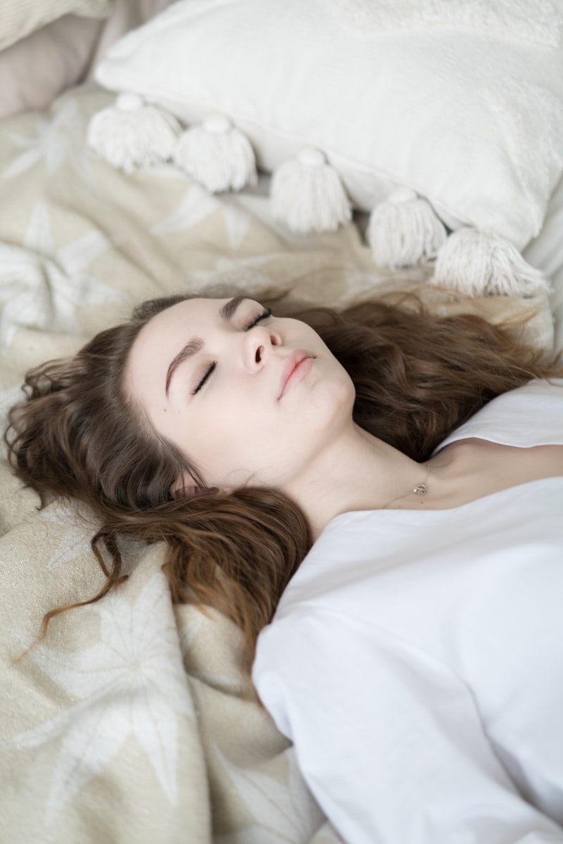 woman sleeping peacefully on white bedding